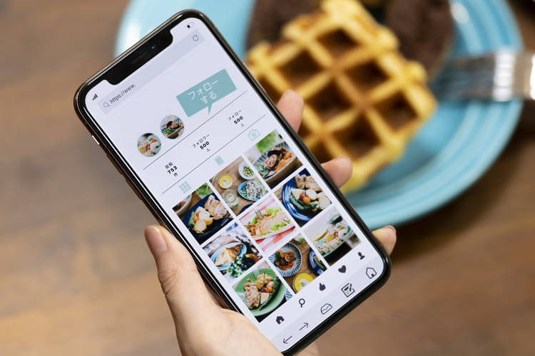 スマートフォンでSNSを見る女性の手元